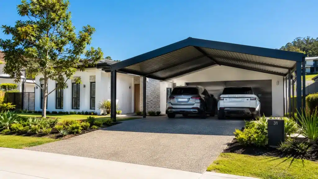 Modern Oxenford home with a Colorbond steel gable roof double carport protecting two SUVs.