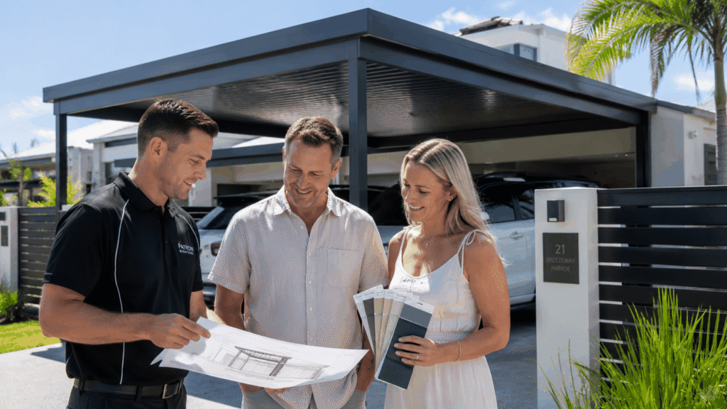 Builder discussing a custom carport project with homeowners outside a completed Labrador home.